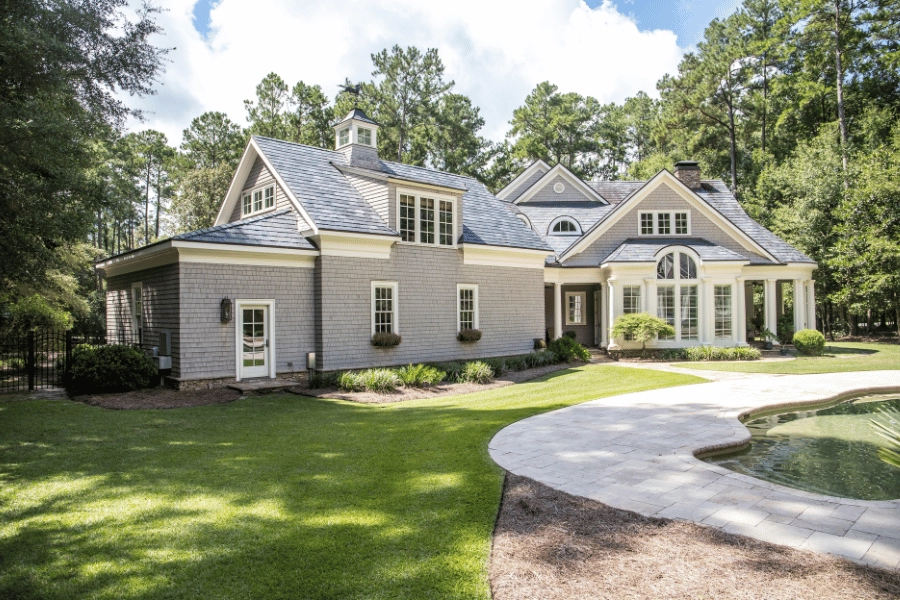 large stunning home with lots of windows and a fenced in backyard